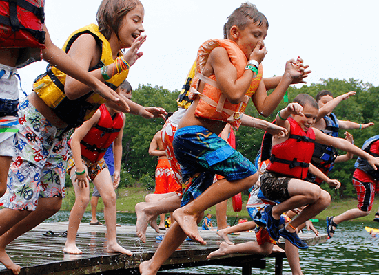 Kids at Summer Camp Run and jump into the lake